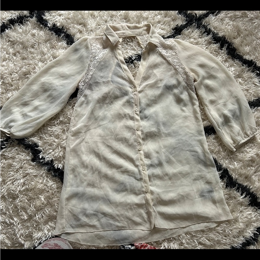 From Vanity it’s a cream colored dressy button down shirt and is a size M